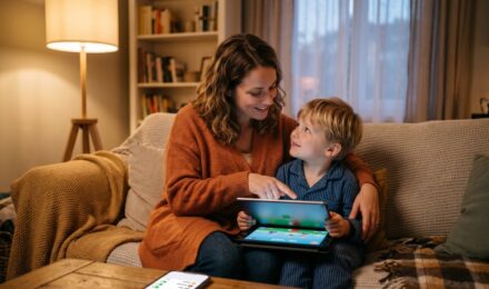 Parent and child using a tablet together with a digital security shield overlay representing online safety tools for kids