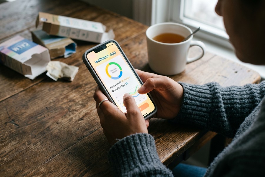 Smart scale and blood pressure monitor on a bathroom counter synced to a health app
