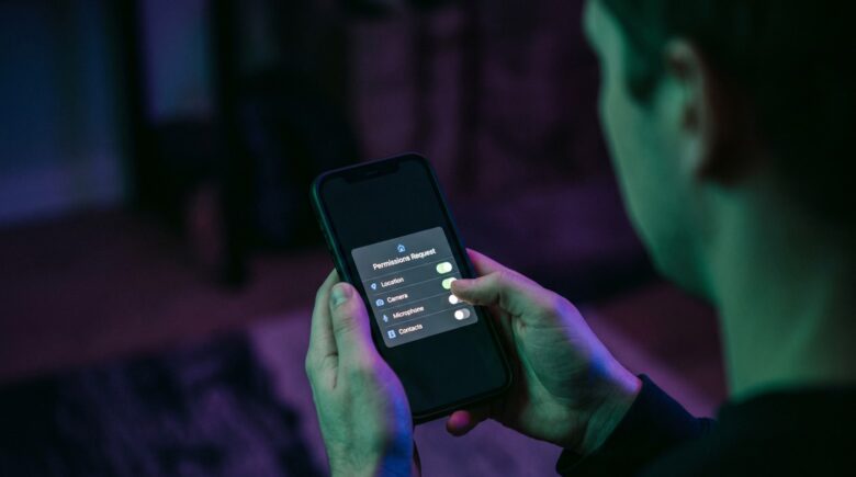 Smartphone screen showing app permissions settings with toggles for camera, microphone, location, and contacts access