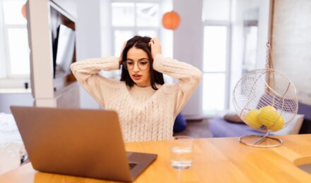 Remote worker looking at phone with group messaging notifications on screen