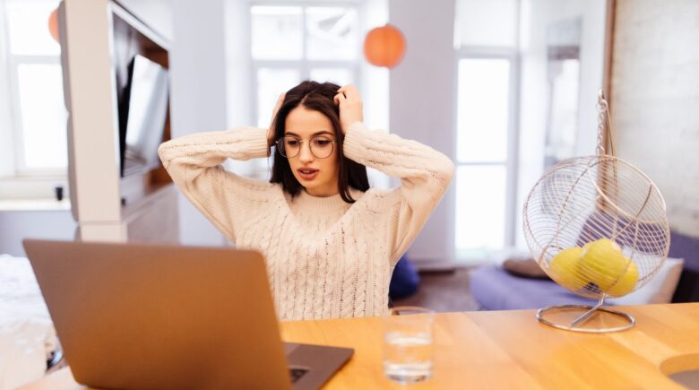 Remote worker looking at phone with group messaging notifications on screen
