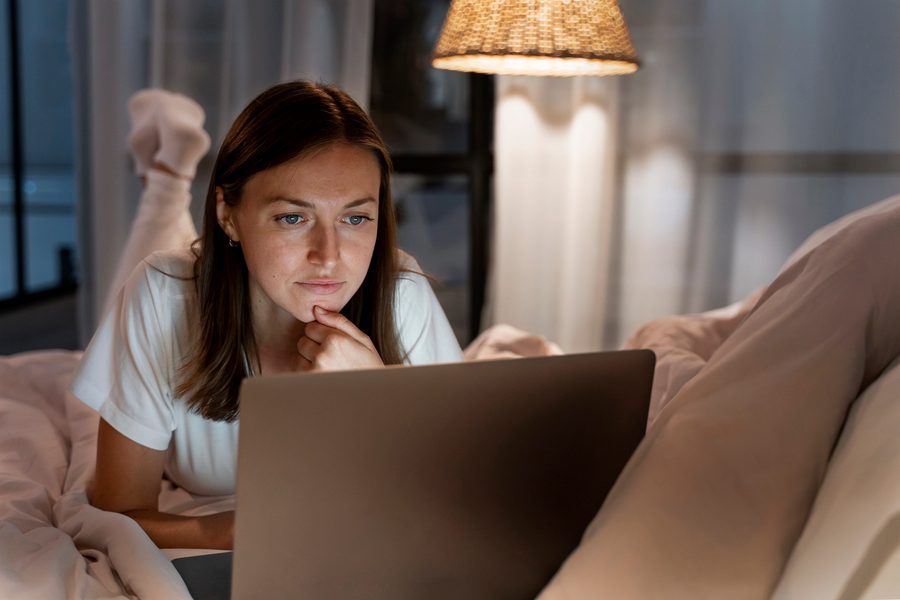 Image showing a person checking phone at night with red-tinted screen glow