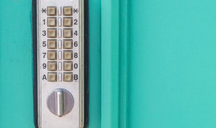 Person holding smartphone up to a smart door lock to unlock it with NFC technology
