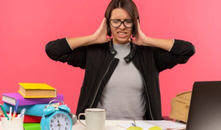 Person at desk with phone in drawer, calm expression, peaceful workspace